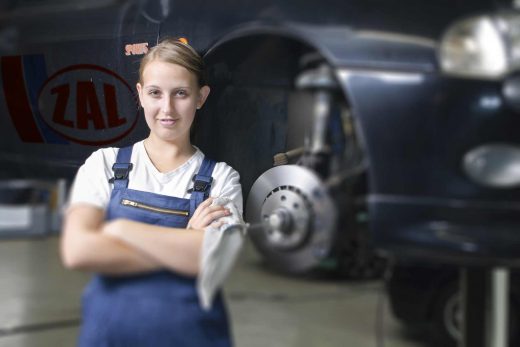 Frau in blauem Overall mit Auto